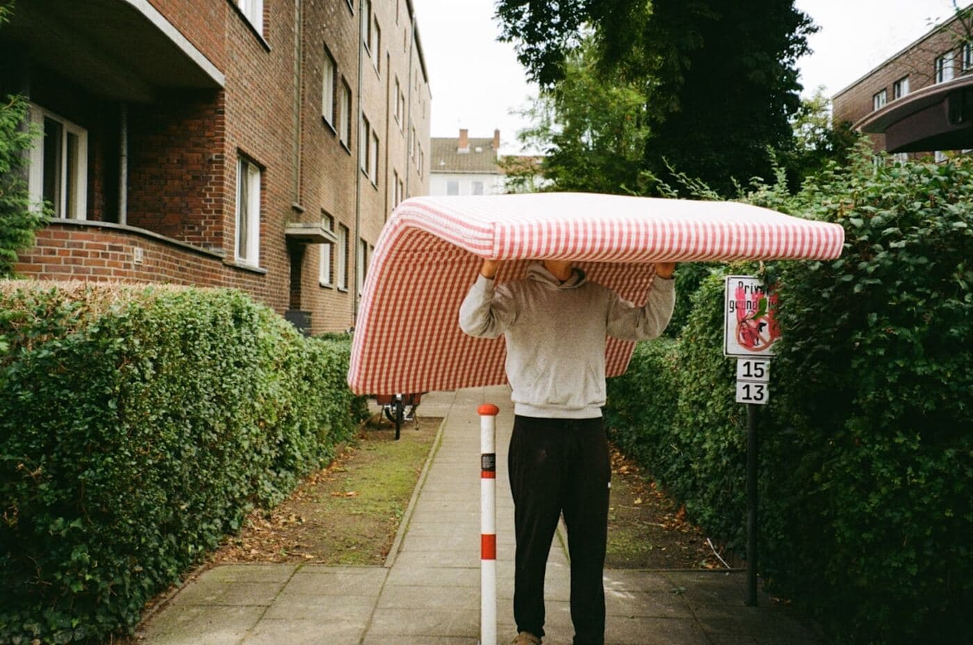 Person carrying furniture down a sidewalk